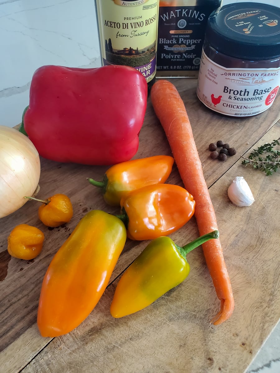 Assorted ingredients for Snapper Escovitch on a cutting board.