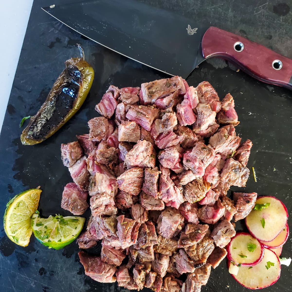 Diced grilled skirt steak for tacos on a cutting board.