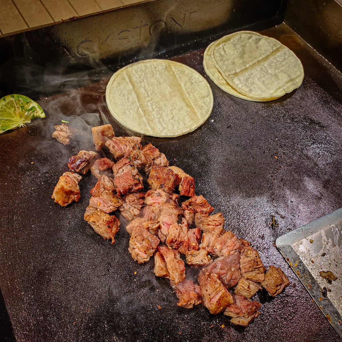 Carne asada street tacos cooking on a Blackstone Griddle.
