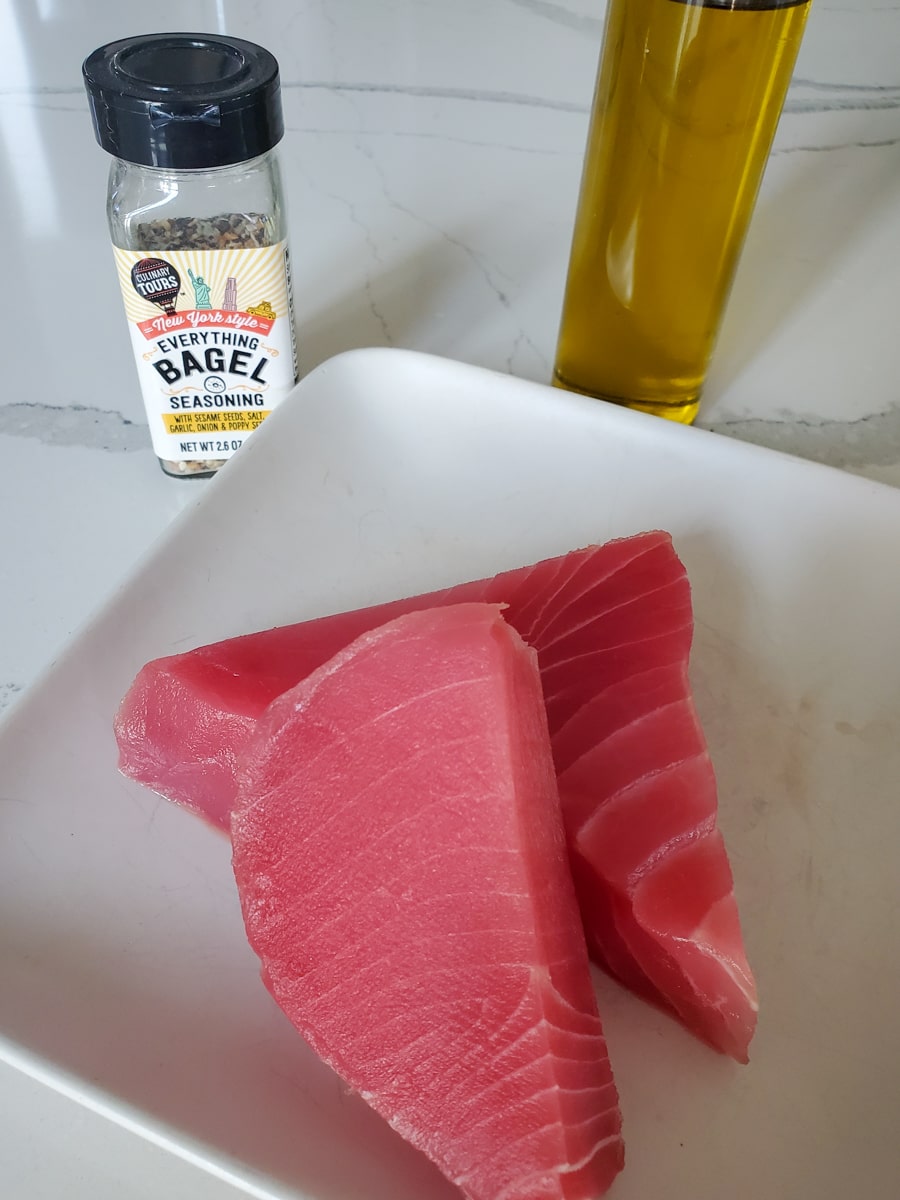 Fresh ahi tuna steaks on a white plate.