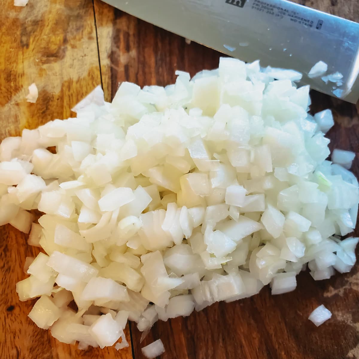 Finely chopped onions on a cutting board.