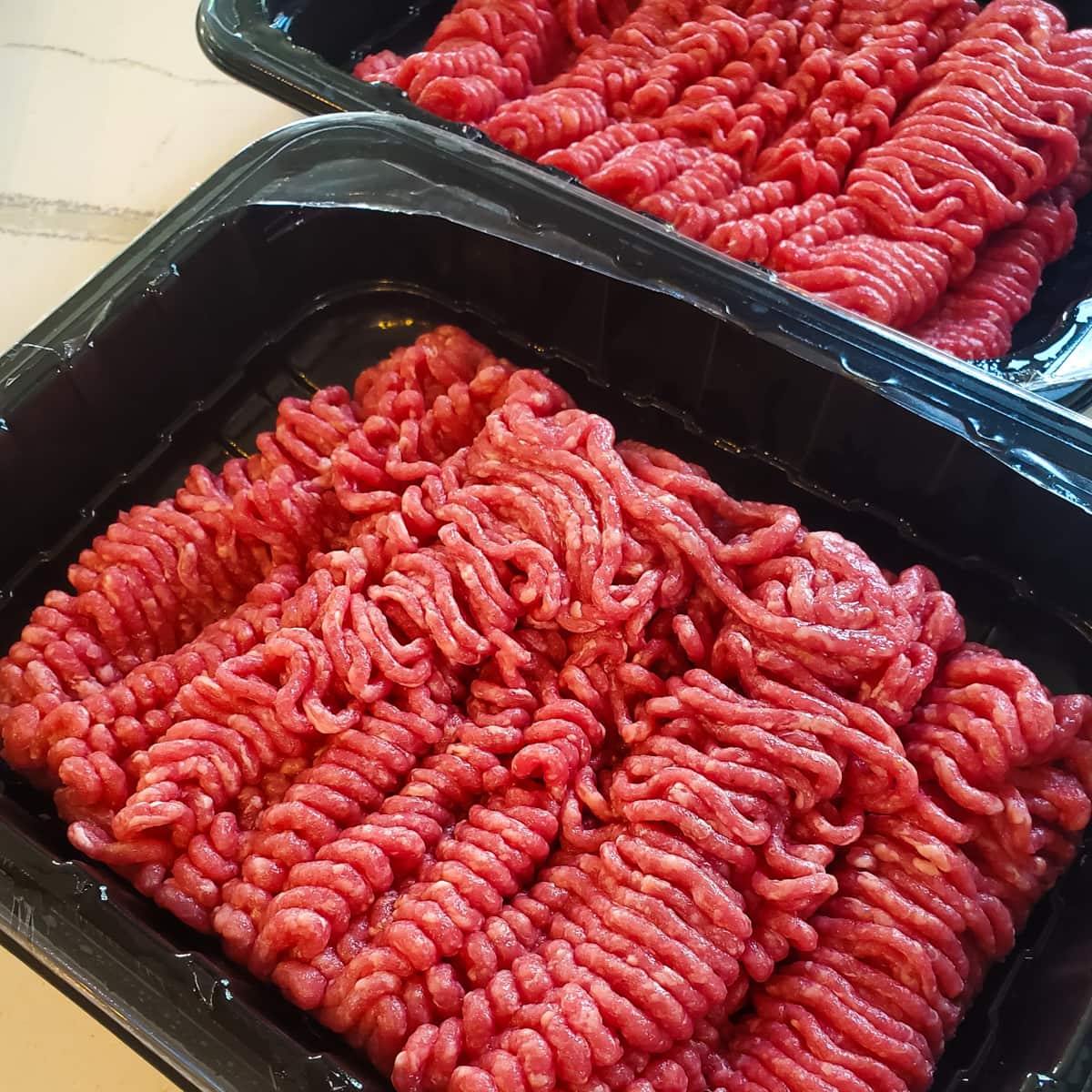 Ground beef in containers.