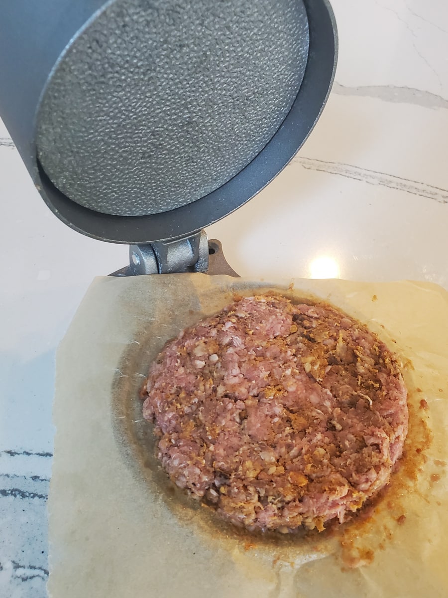 Burger press being used to make burger patties.