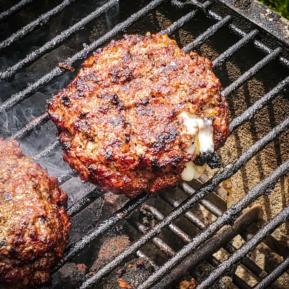Chorizo burgers cooking on a PK Grill.