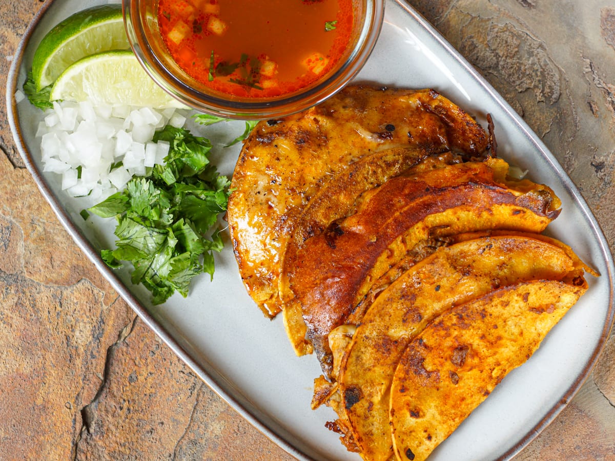 Quesabirria tacos served with consommé.