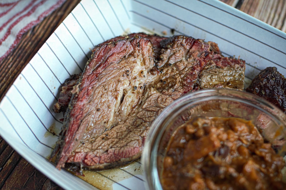 Slice of smoked Texas brisket with smoked baked beans.