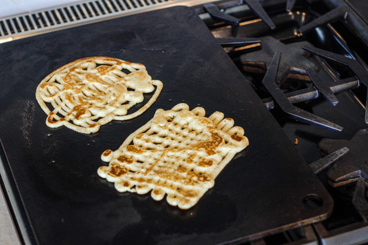 Making funnel cakes on a griddle.