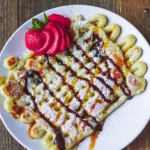 Blackstone funnel cake with strawberries, chocolate and caramel.