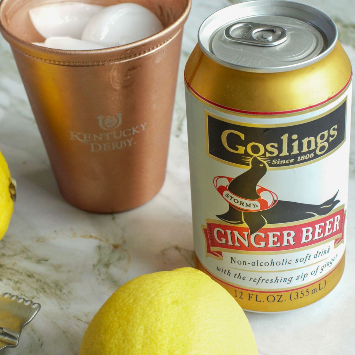 Ice, lemon and Goslings Ginger Beer on a counter.