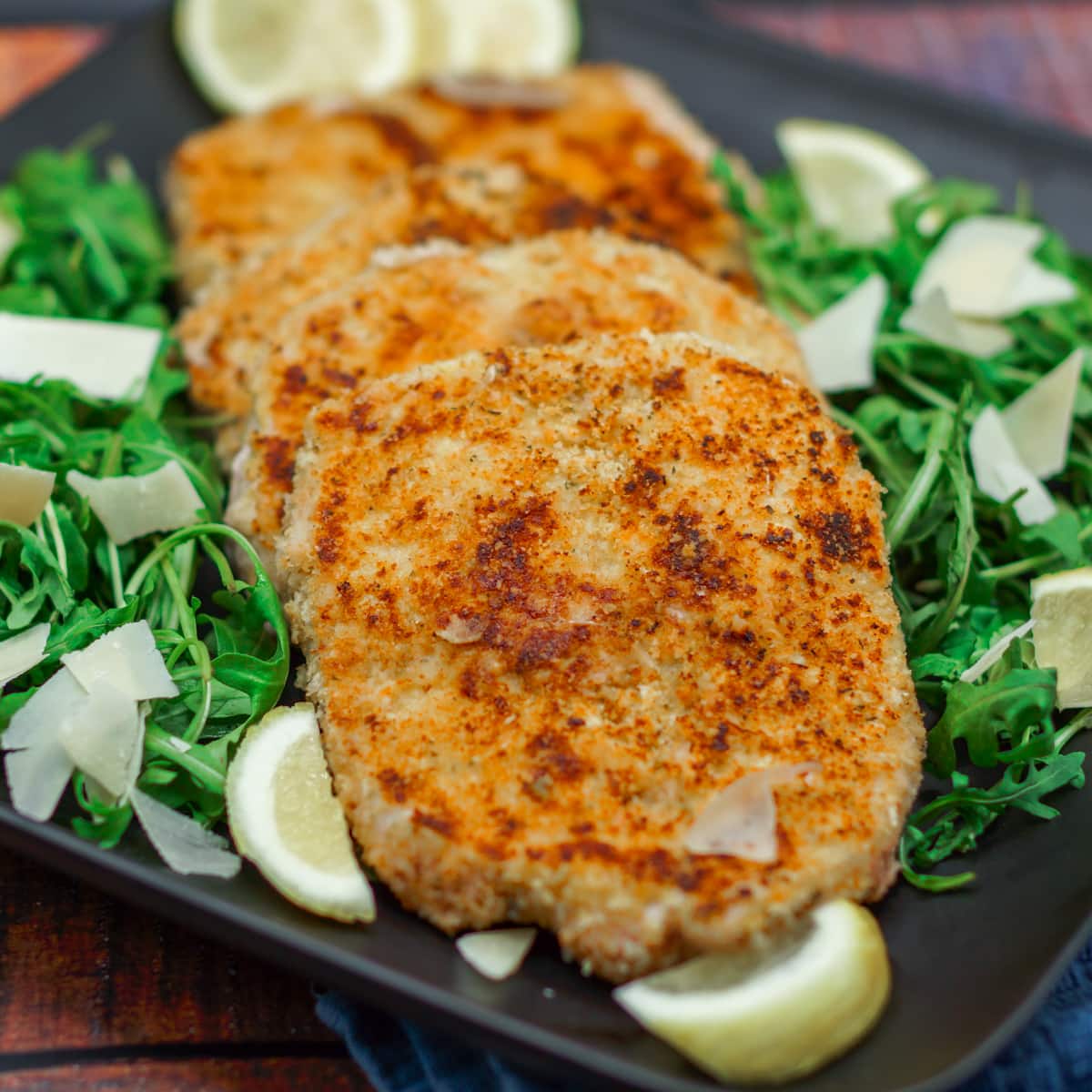 Butterfly pork chop Milanese style served with arugula and parmesan.