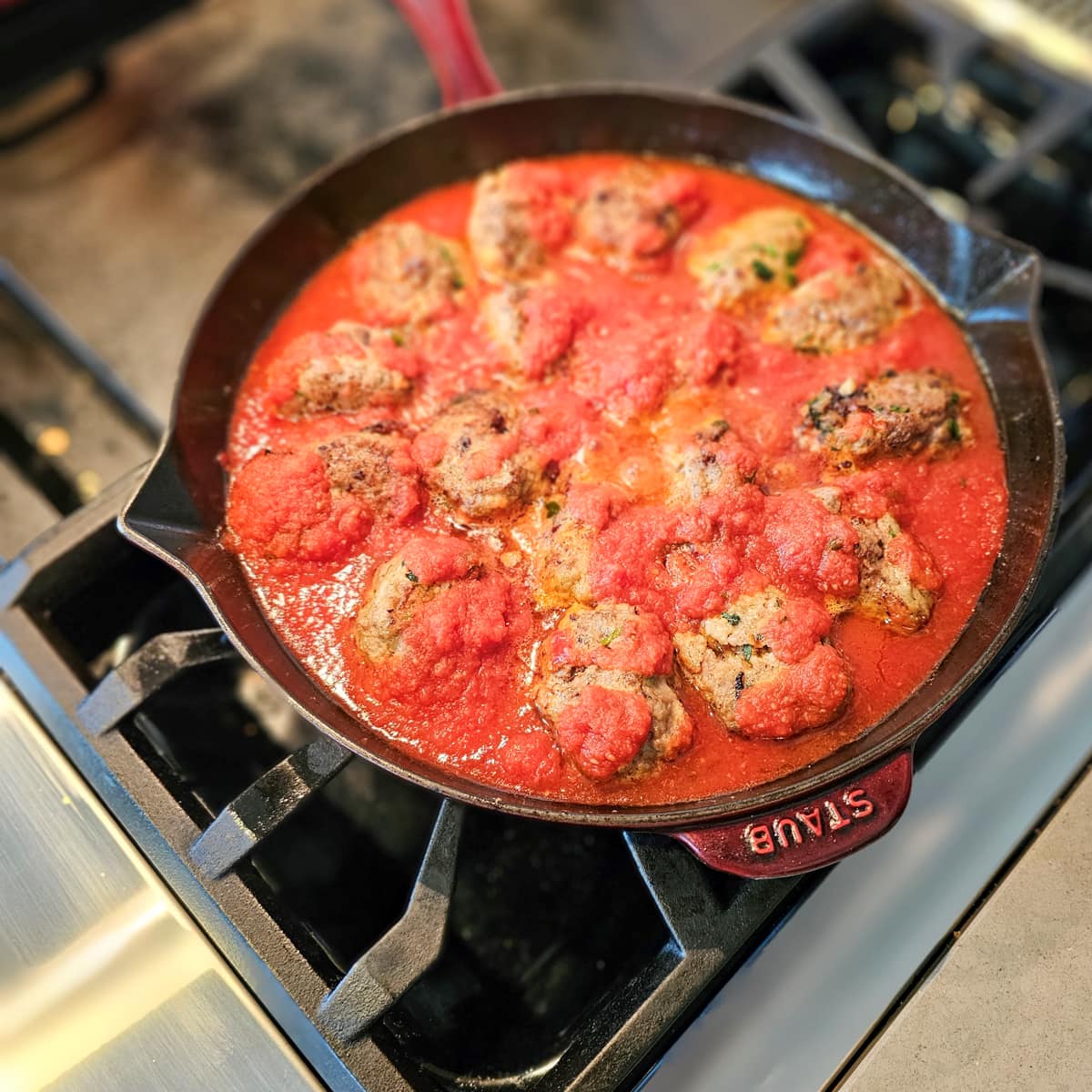 Sicilian meatballs simmering in marinara.