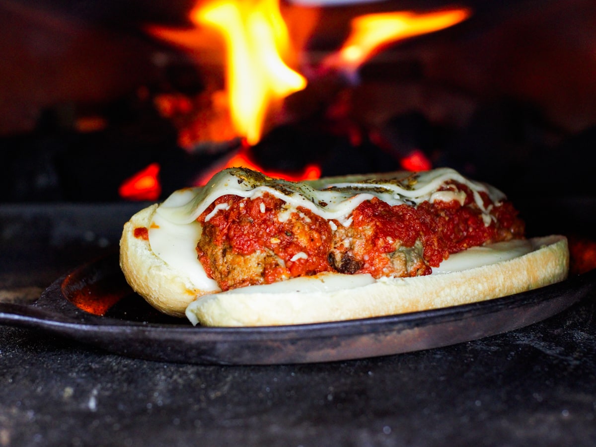 Meatball sub cooking in an ooni pizza oven.