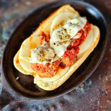 Wood fire pizza oven cooked meatball grinder sandwich.