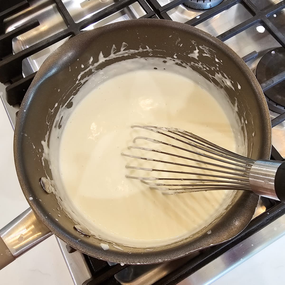 Making homemade bechamel in a sauce pan.