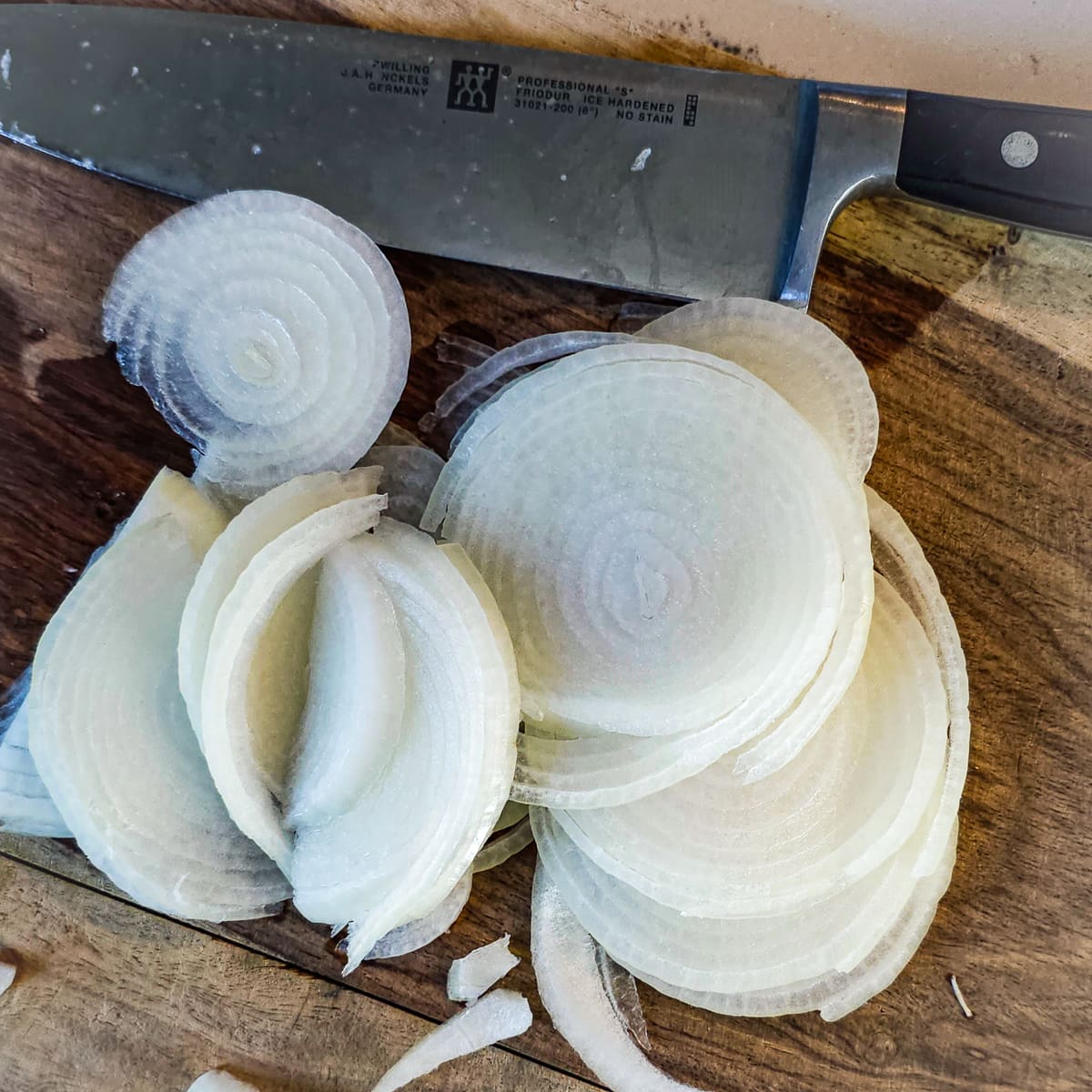 Onions sliced on a cutting board.