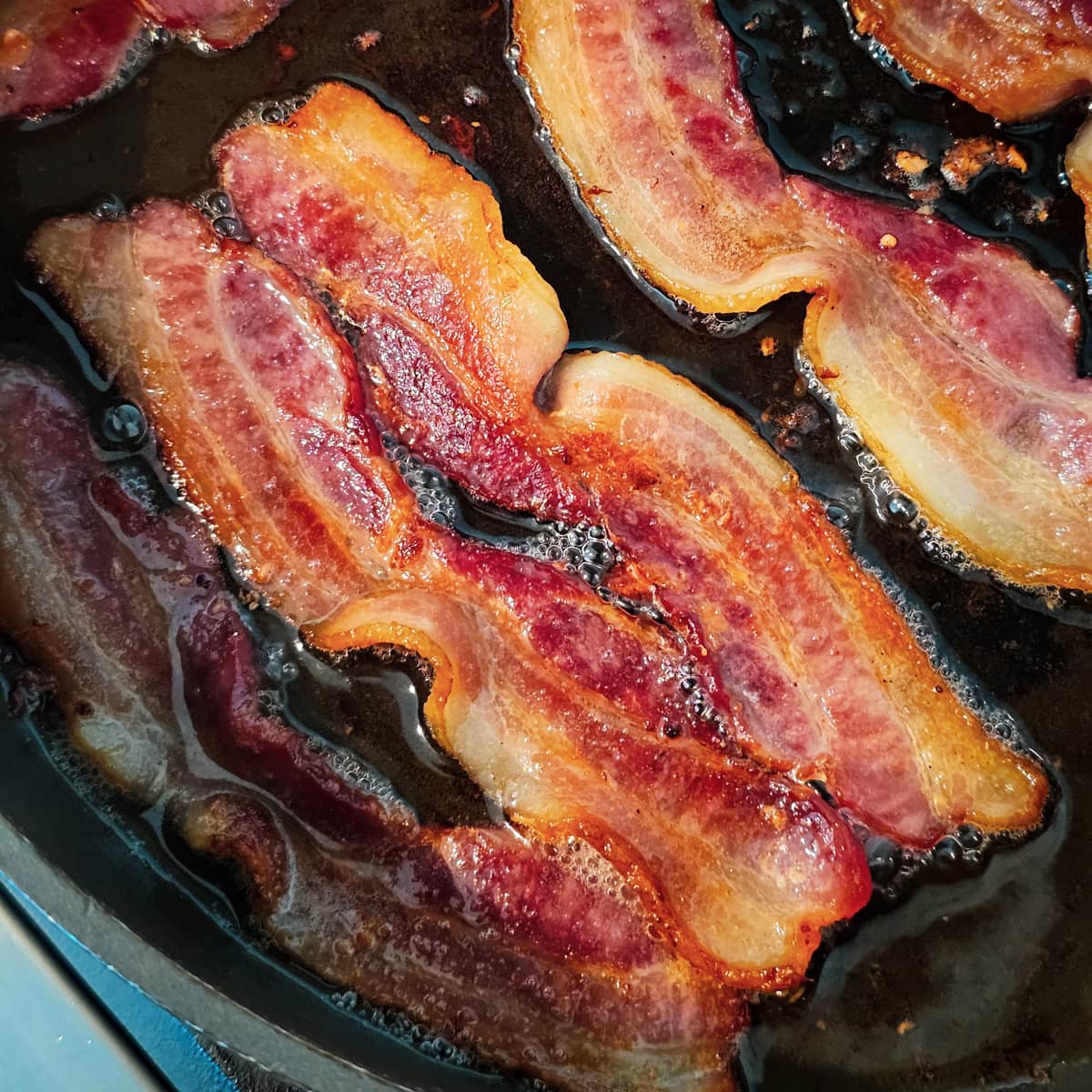 Bacon frying in a skillet.