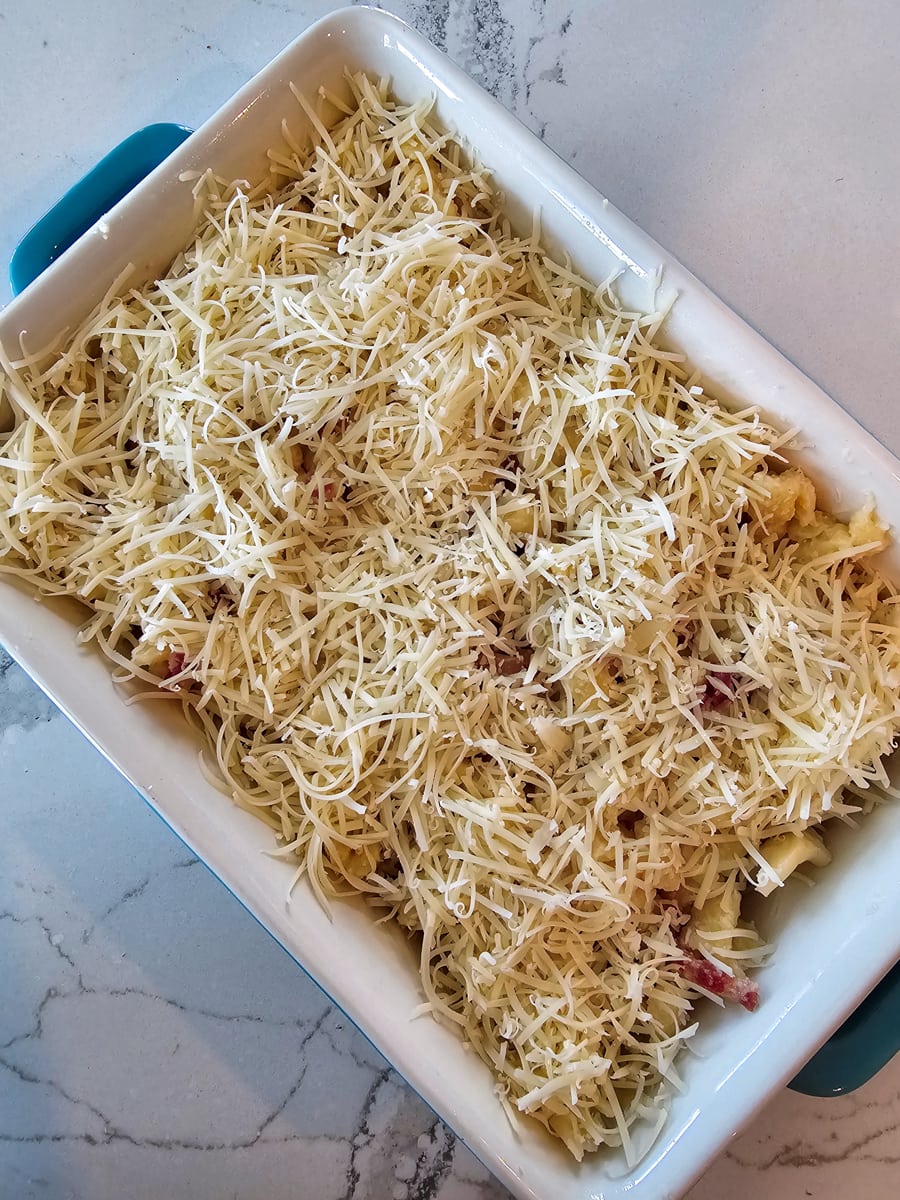 Kaesespaetzle topped with cheese in a casserole dish.