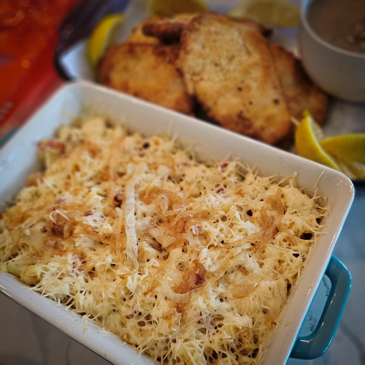 Cheesy Kasespätzle with bacon in a casserole dish.