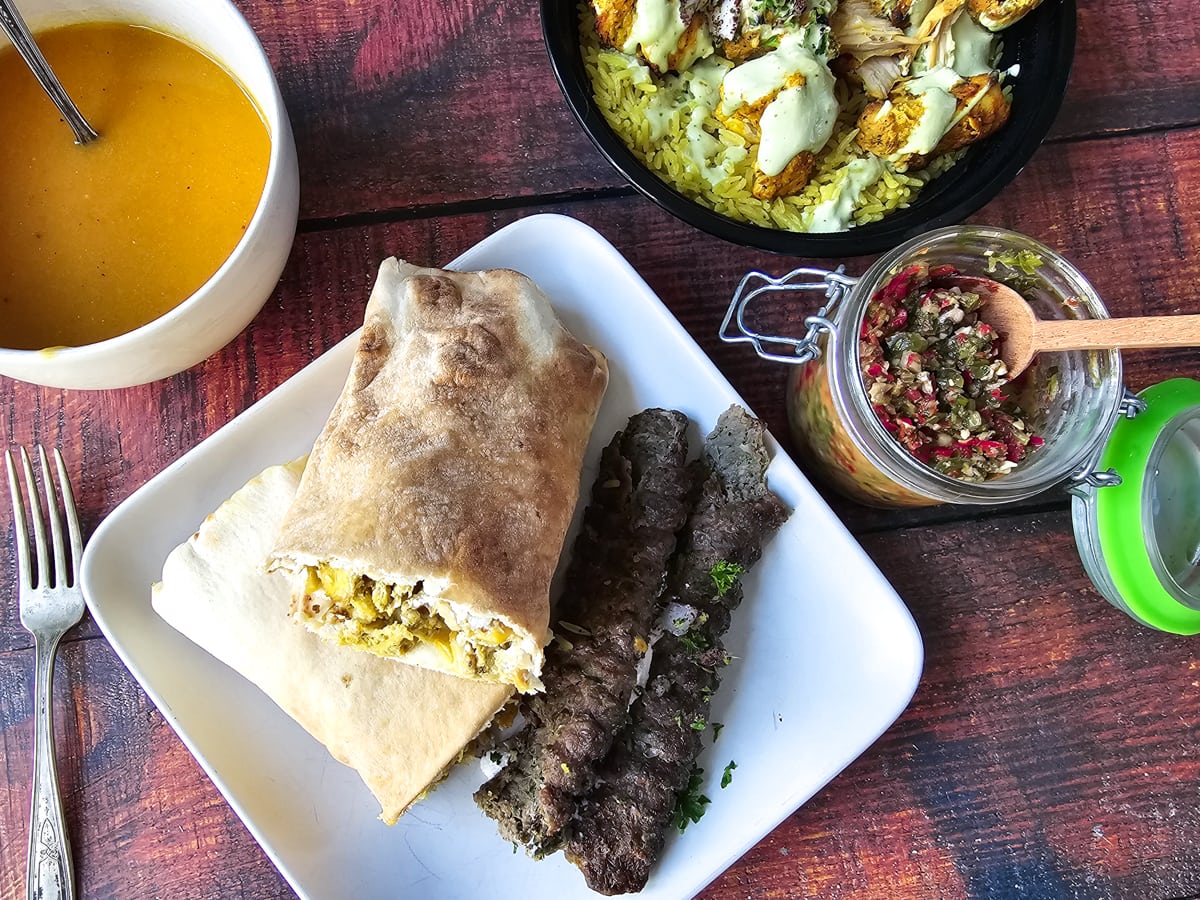 Middle Eastern dinner with kefta, shawarma wrap, shish tawouk, and shatta sauce.
