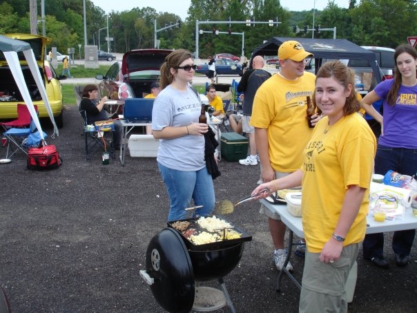 Tending a grill at a football tailgate.