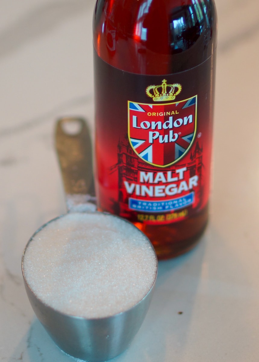 Malt vinegar and sugar on a countertop.