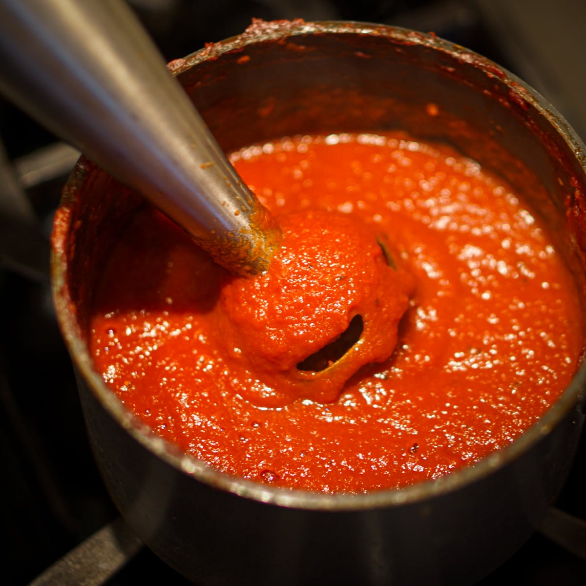 Blending homemade ketchup with an immersion blender.