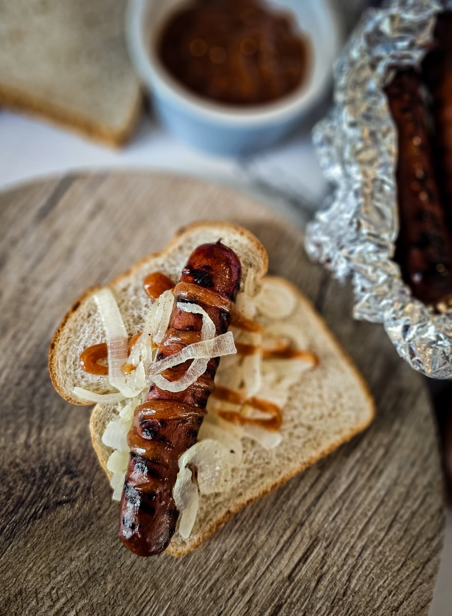 Australian sausage sizzle topped with grilled onions and homemade ketchup.