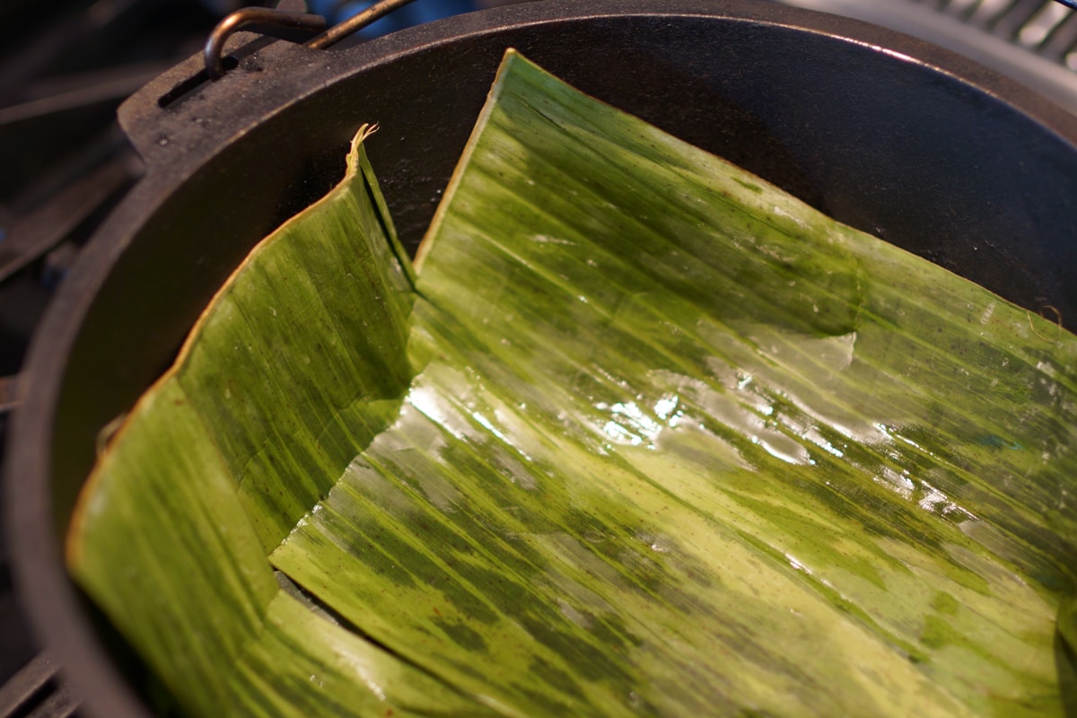 Cast iron Dutch oven lined with banana leaves.