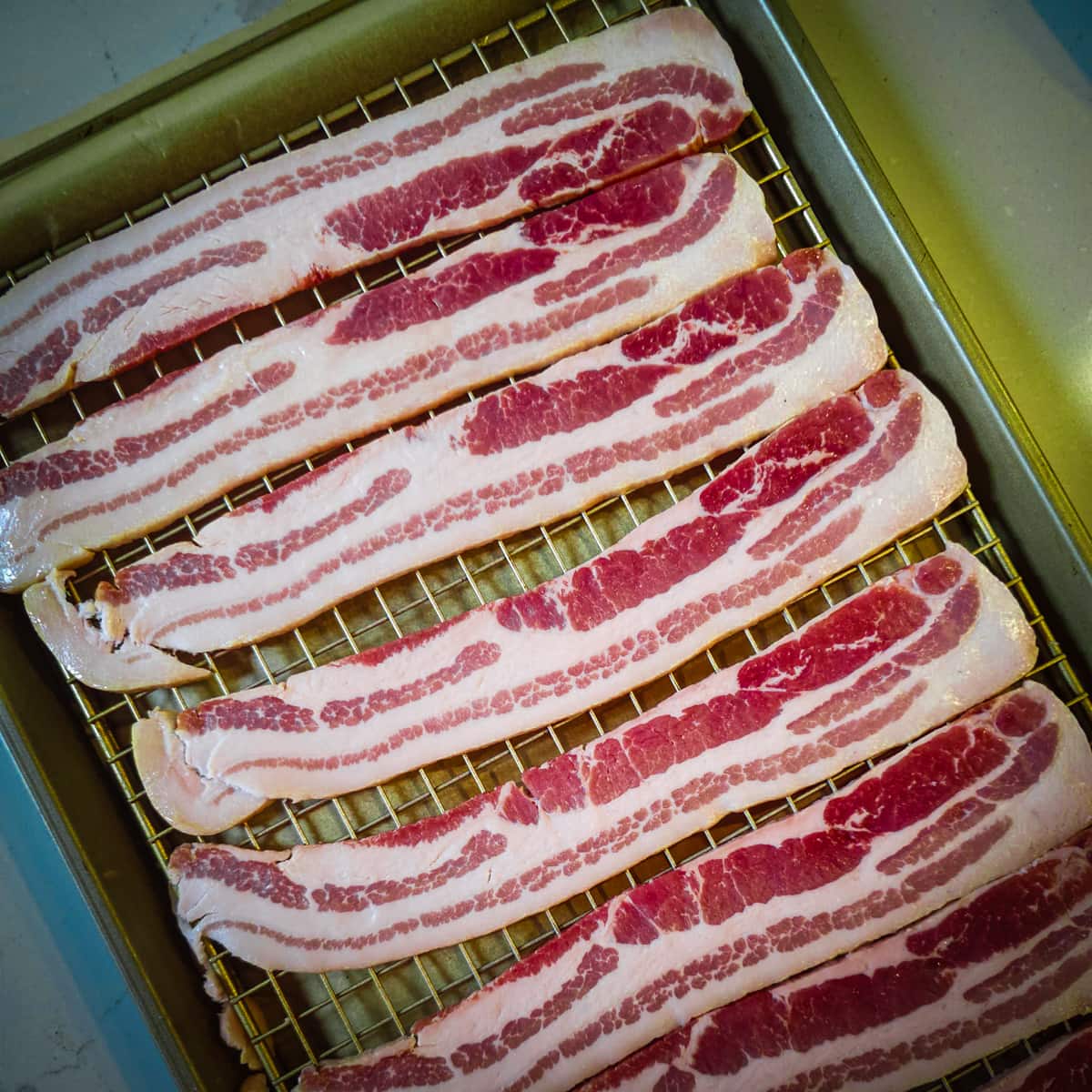 Slices of center cut bacon on a wire rack.
