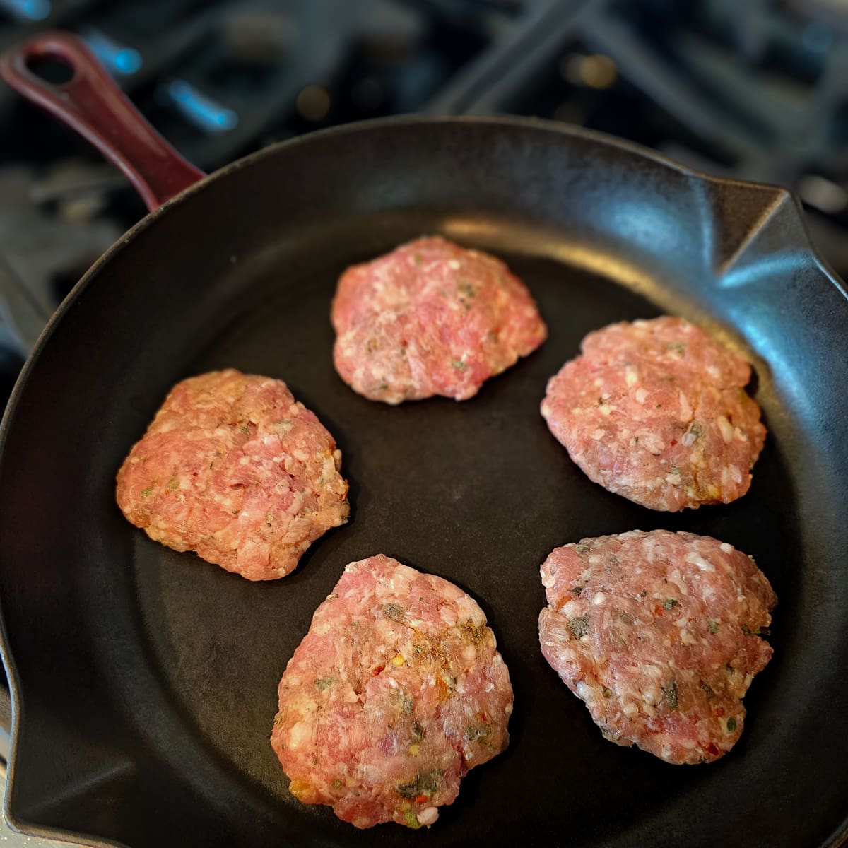Homemade sausage cooking in a skillet.