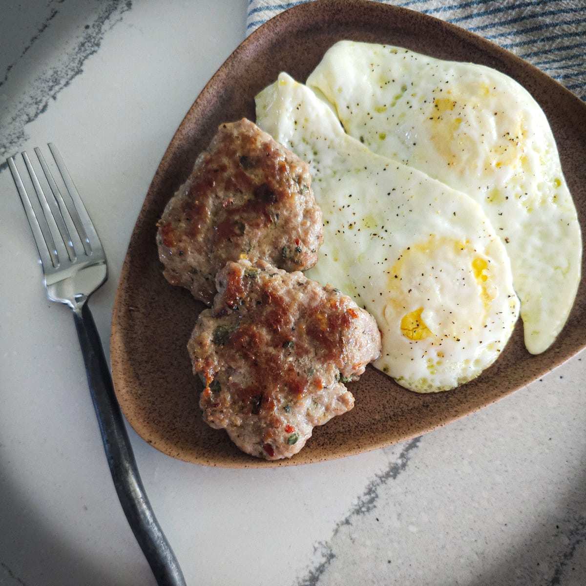 Fried homemade sausage patties with fried farm fresh eggs.