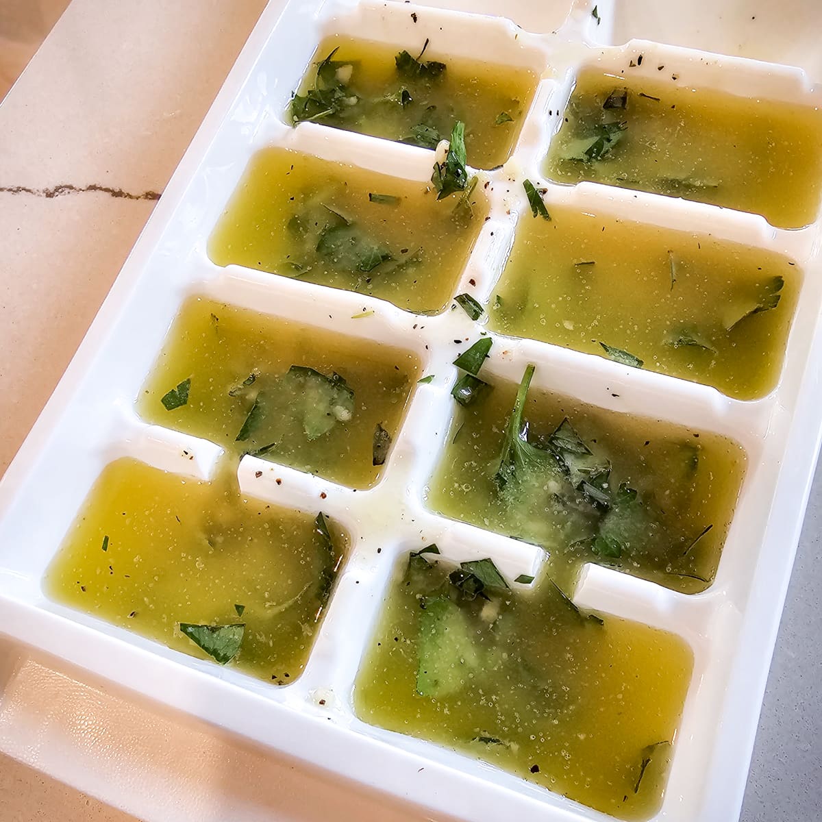 Fresh herb butter in an ice cube tray.