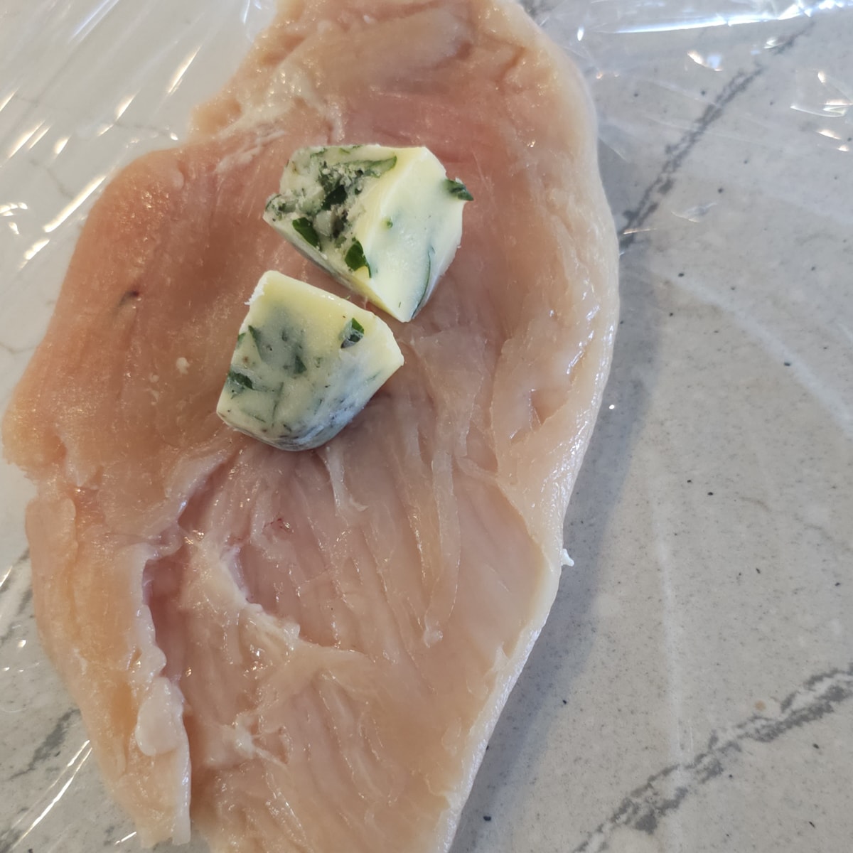 Fresh herb butter cubes on a chicken breast, for chicken Kiev.