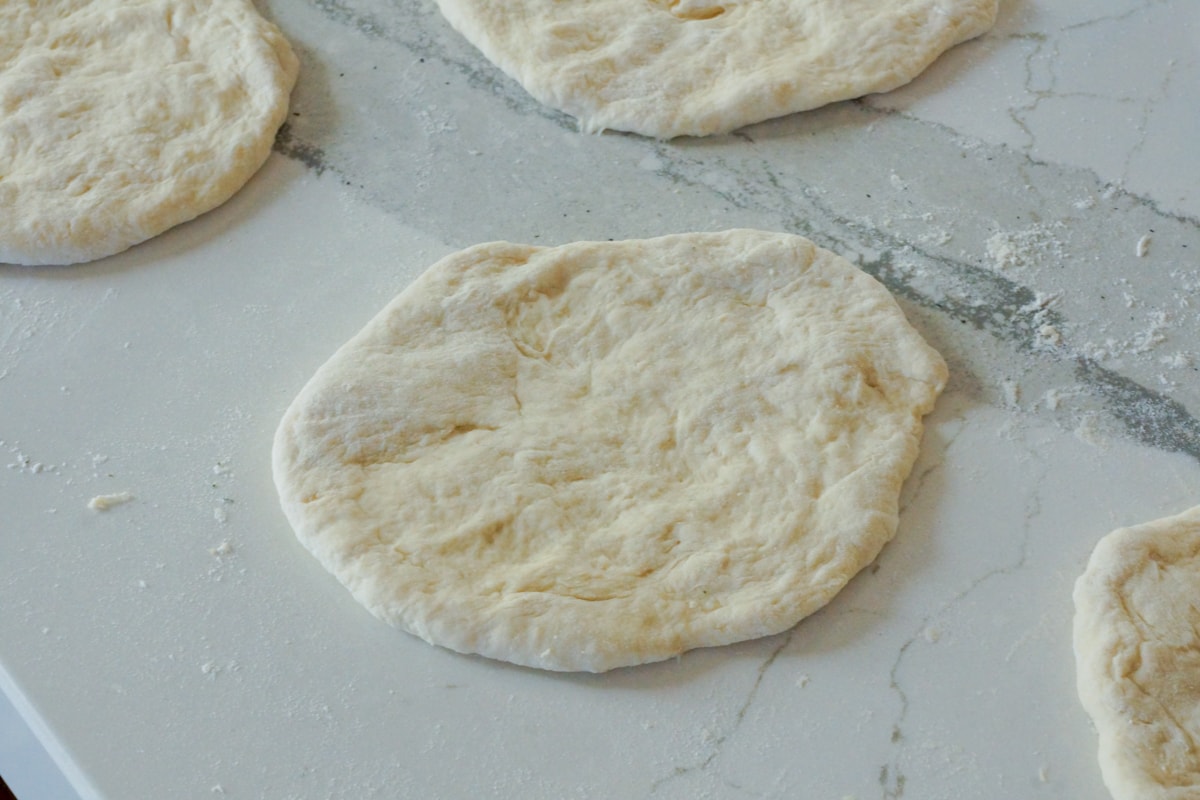 Fry bread dough rolled on a floured counter.