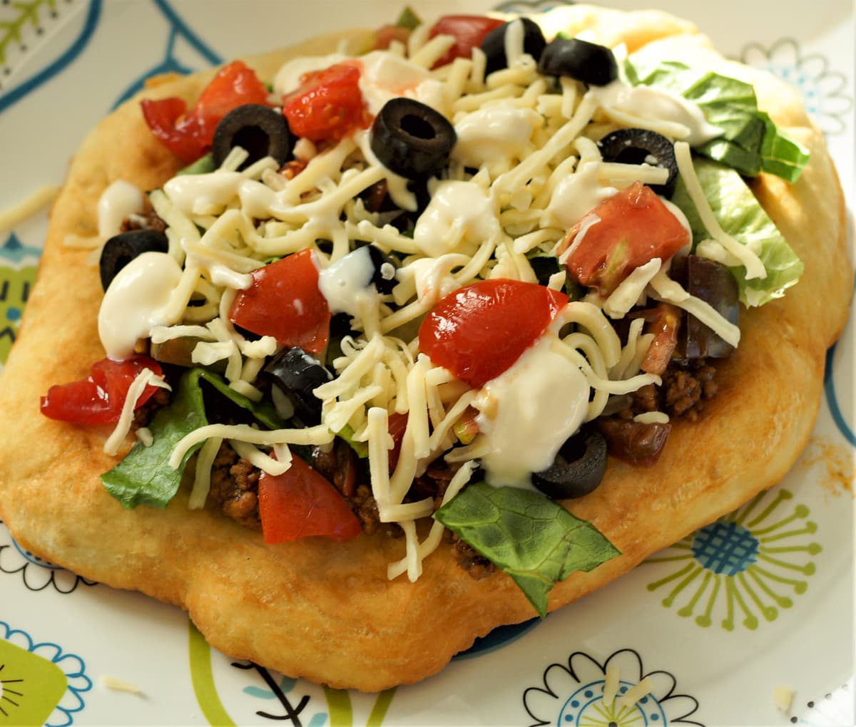 Navajo fry bread taco on a decorative plate.