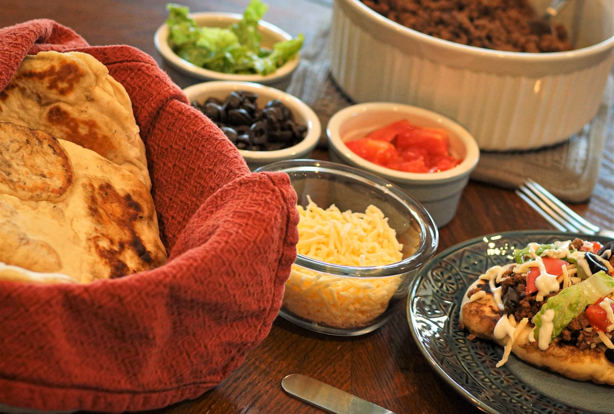 Assorted toppings for Navajo tacos, on a table.