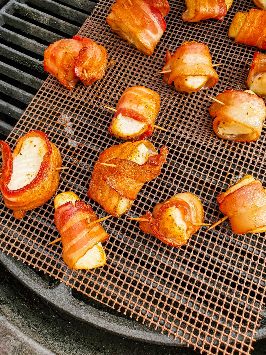 Bacon wrapped halibut cheeks on a frog mat and grill.