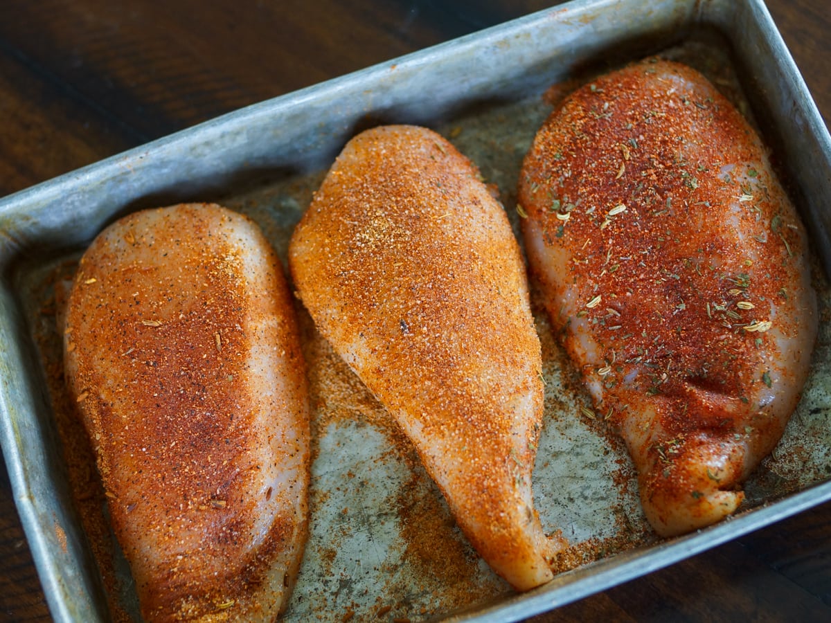 Chicken breast seasoned with homemade blackening seasoning in a pan.