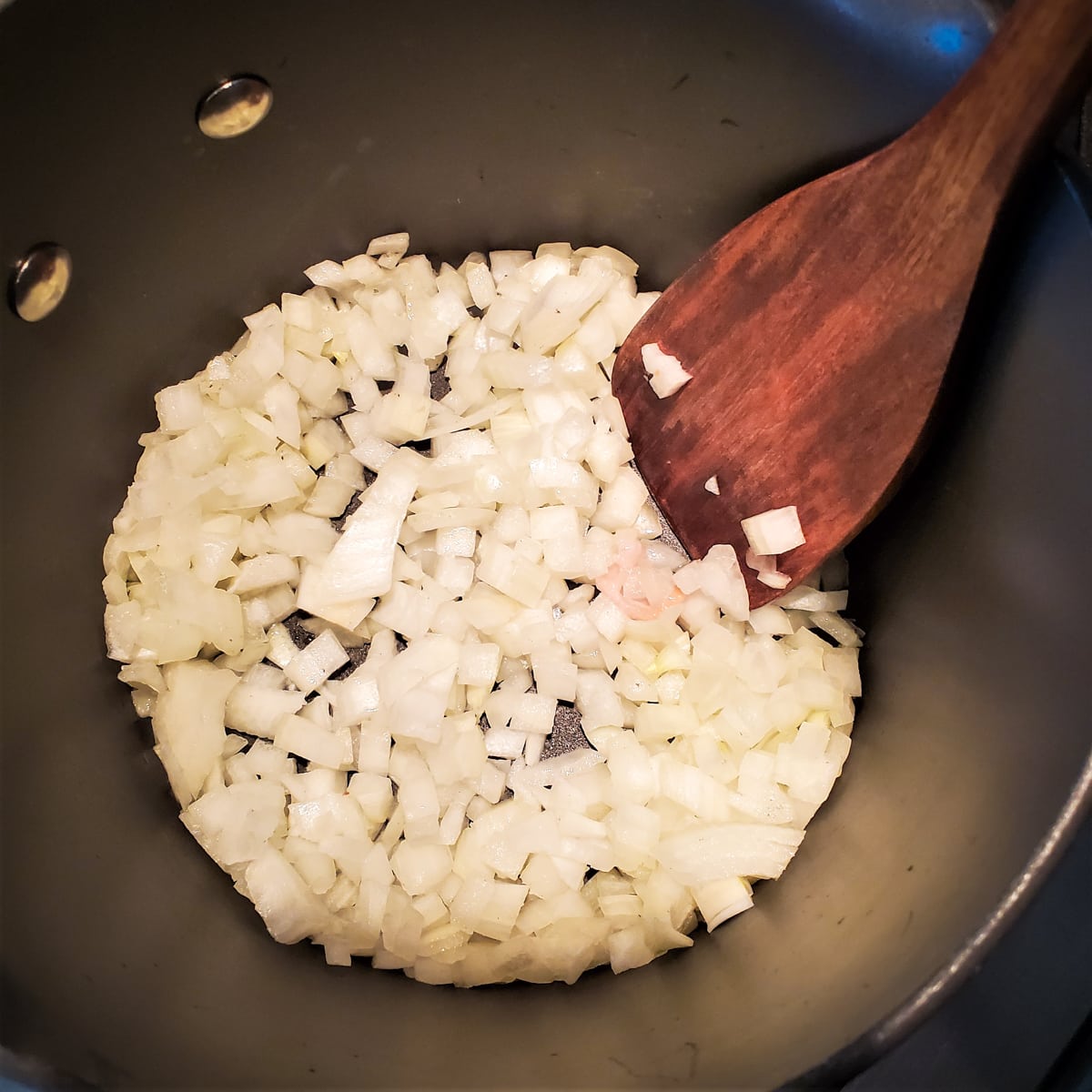 Diced onion cooking in a pot.