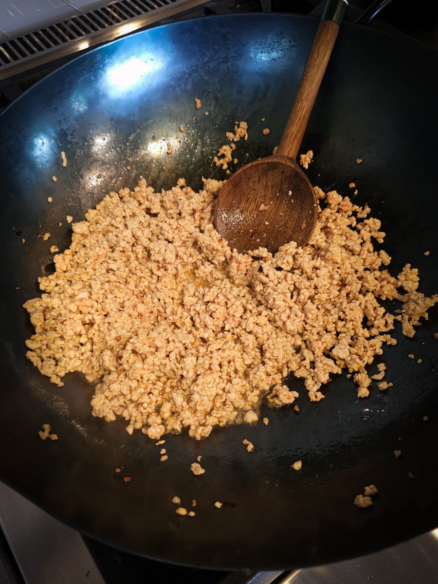 Ground pork cooking in a wok.