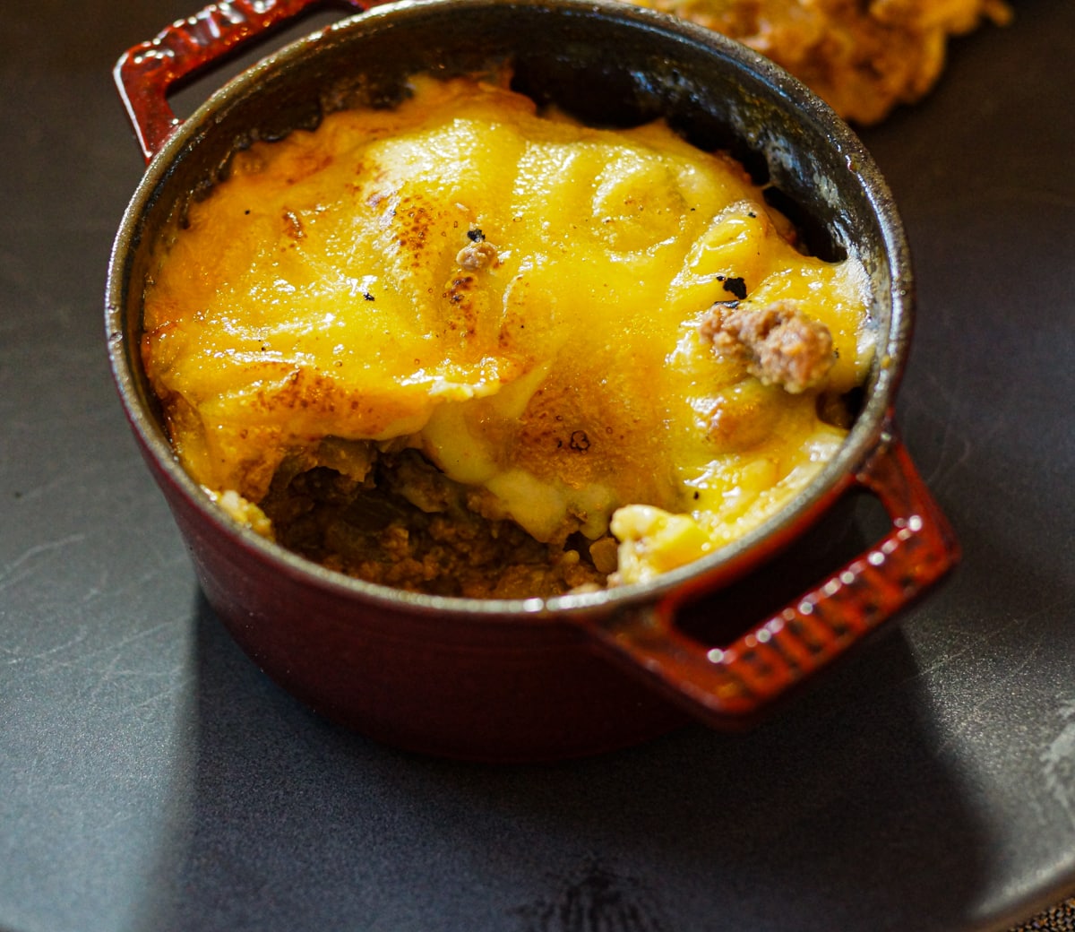 Keshi Yena, the National dish of Aruba in a red cocotte.