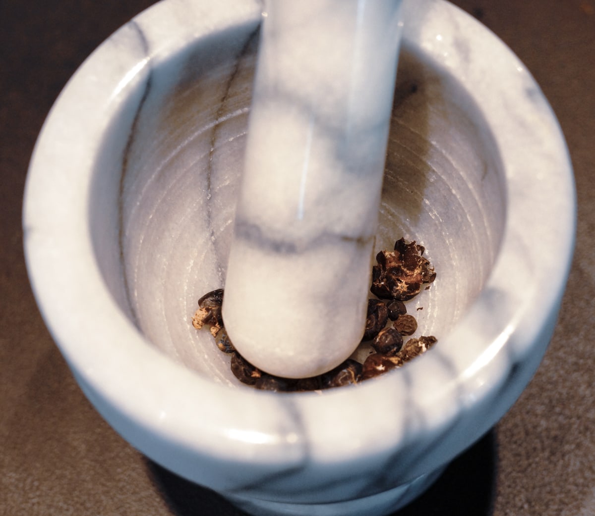 Crushing spices with a mortar and pestle. 