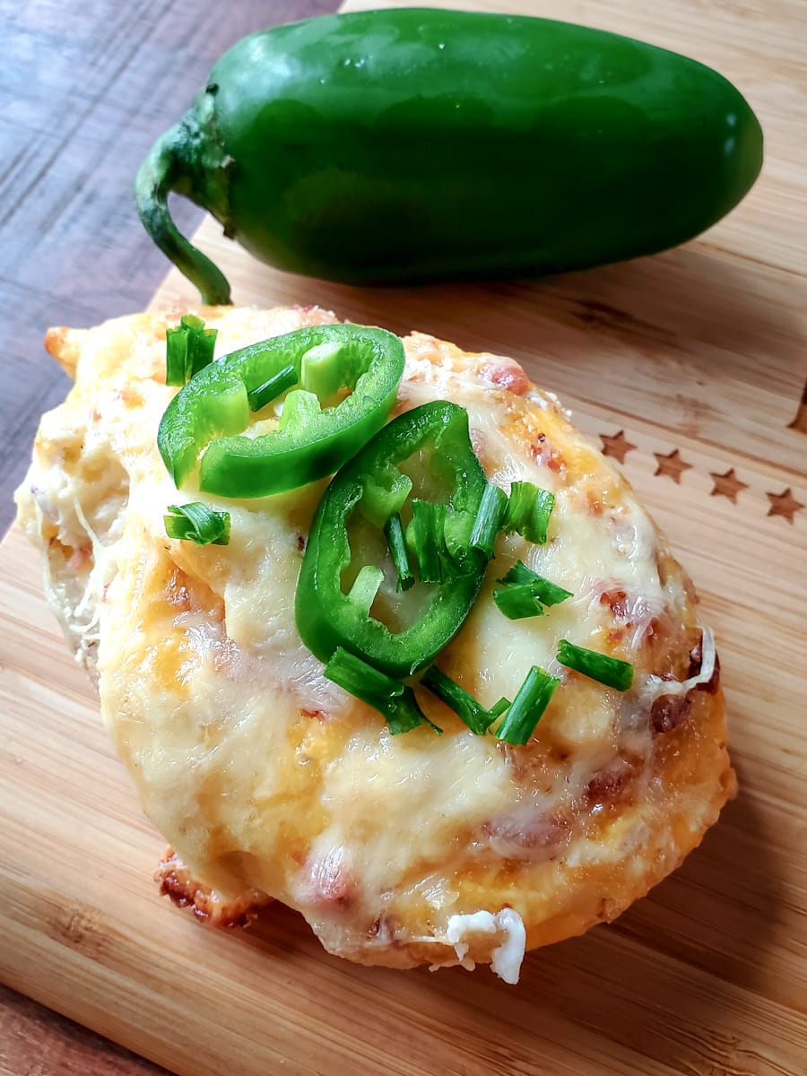 Close up of Jalapeno twice baked potato on a cutting board with a jalapeno pepper.