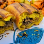 Flaky pastry flakes off as the Jamaican beef patties are cut in half to reveal the seasoned beef filling.
