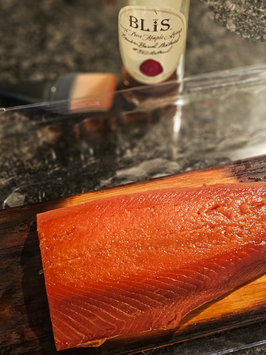 Salmon next to a bottle of bourbon maple syrup.