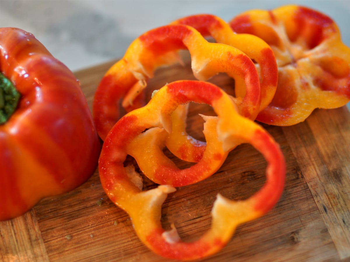 Slices of multicolor bell pepper on a cutting board.