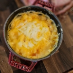 Small cast iron cocotte with BBQ cheese and ham bake.