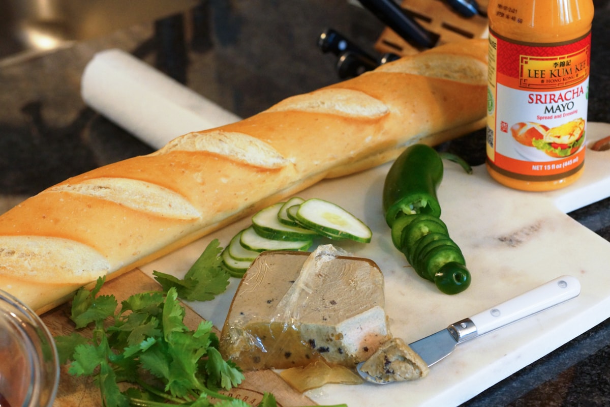 Pate, baguette, and sriracha mayo prepped to make a Banh Mi sandwich.