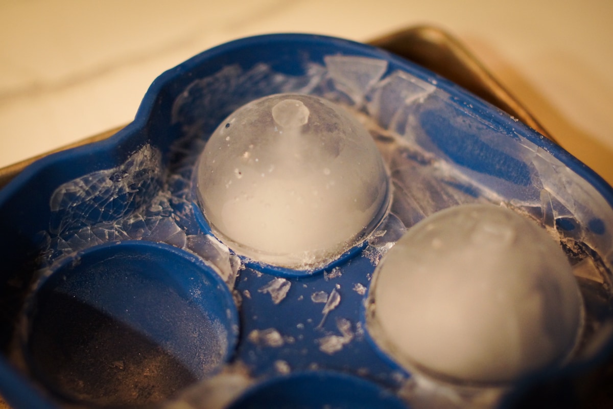 Circular ice cubes being removed from ice molds.