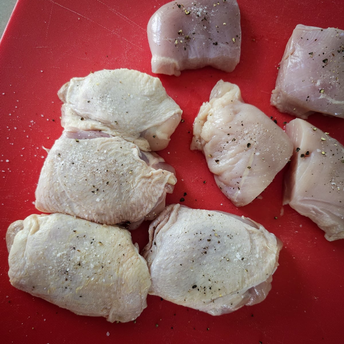 Chicken thighs seasoned with salt and pepper.